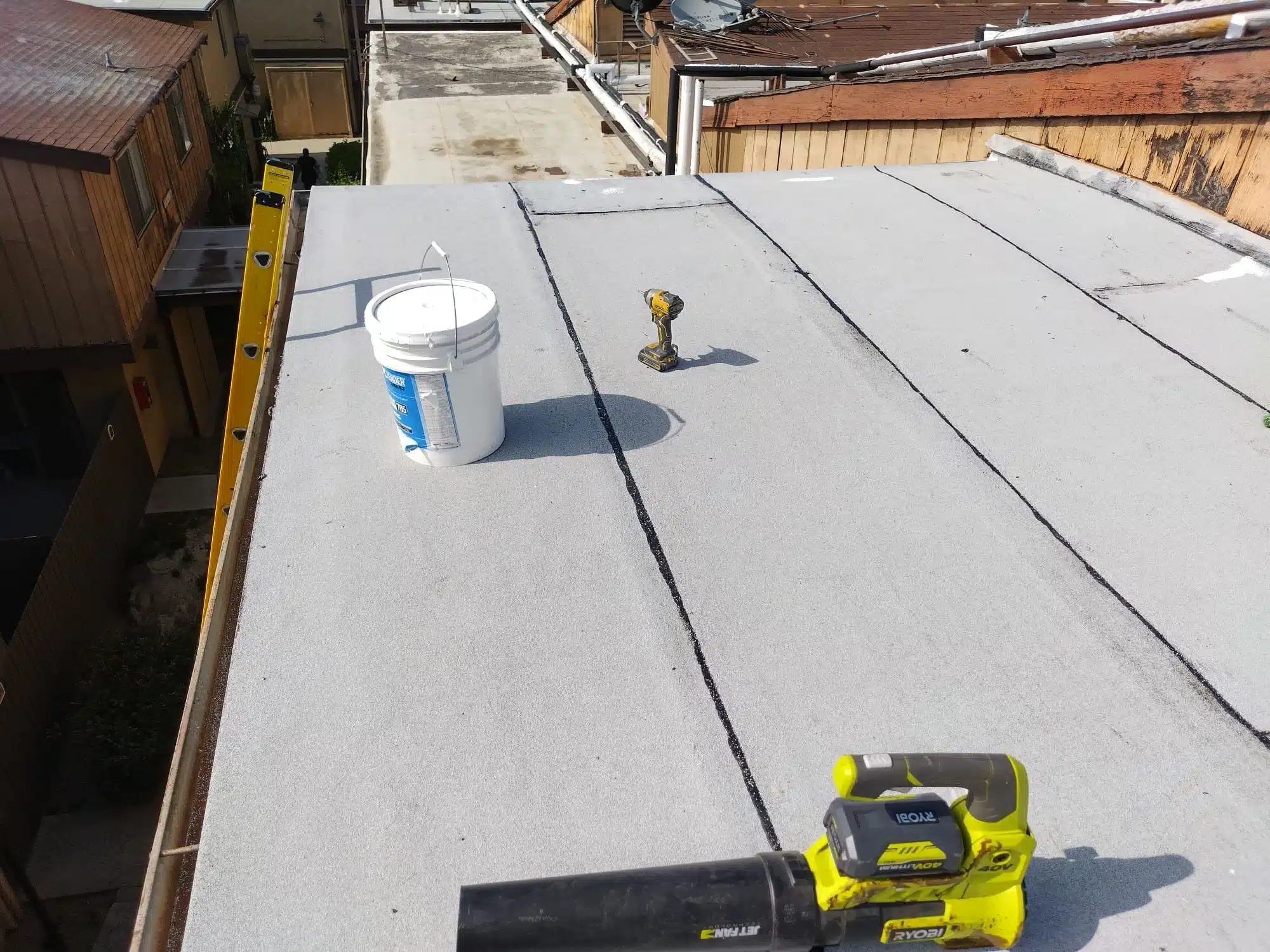 1-Jun 05 2024 09_22am-QLAR Commercial flat roof with a fresh coating and repair tools