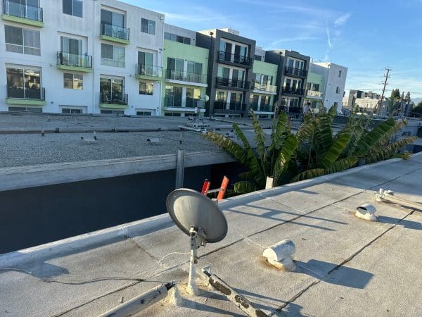 Flat roof surface with sealed penetrations and drainage