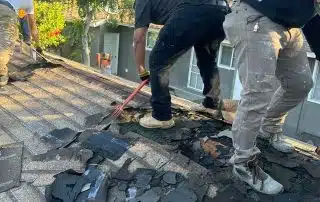 Removing old damaged shingles during roof replacement in Glendale, CA