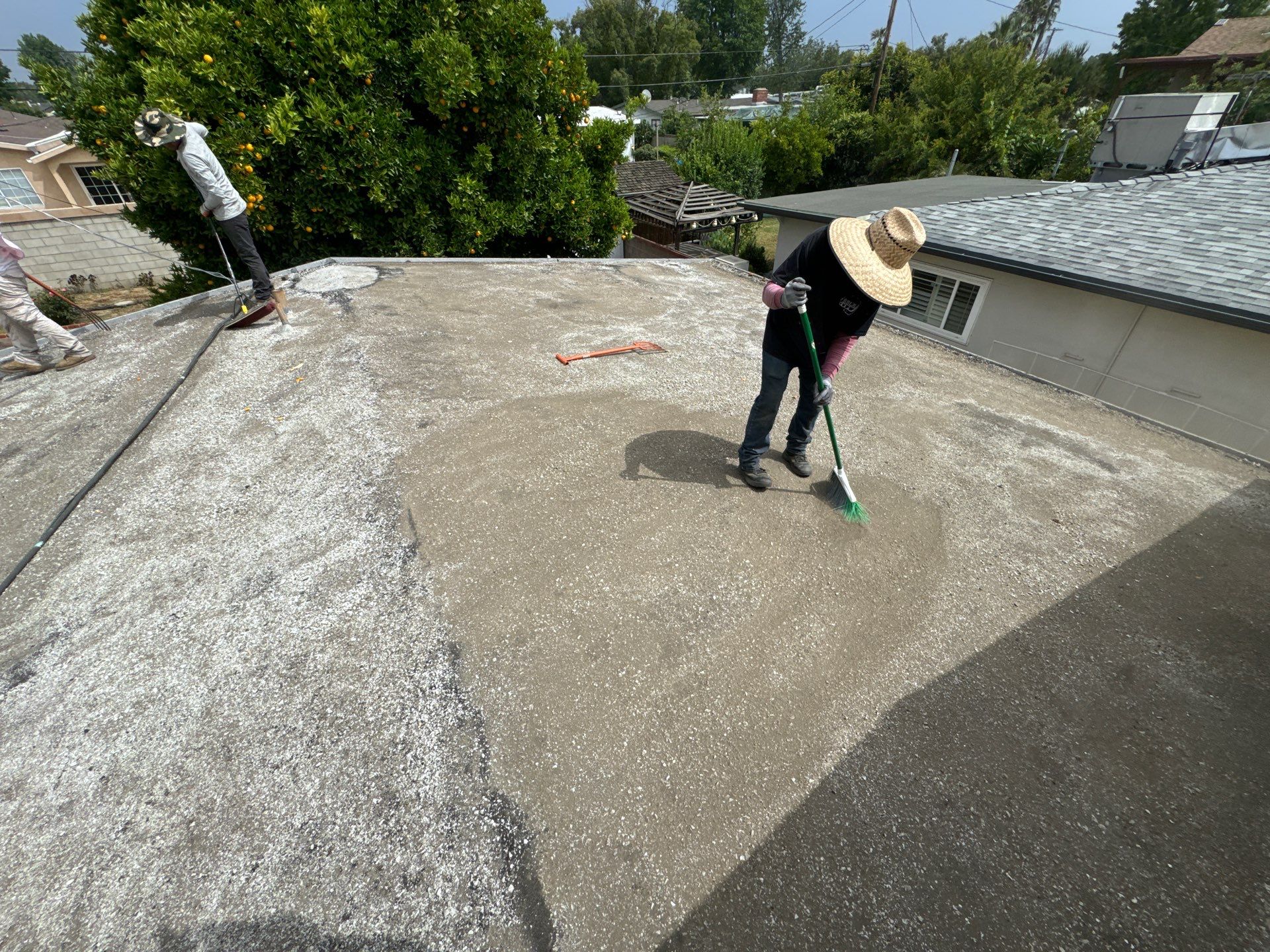 roofers applying new gravel to torched down roof