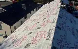 Roofers inspecting underlayment