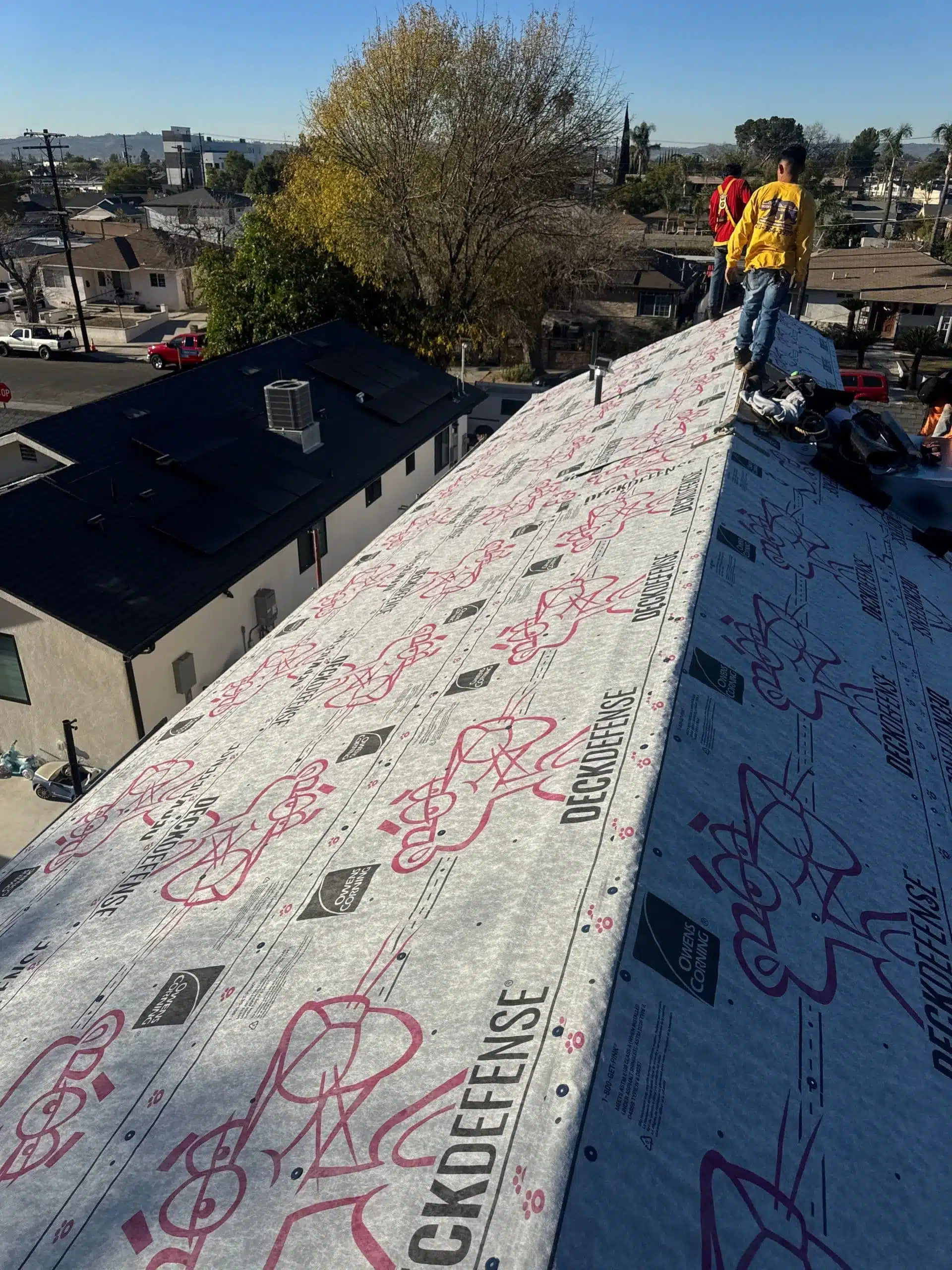 Roofers inspecting underlayment