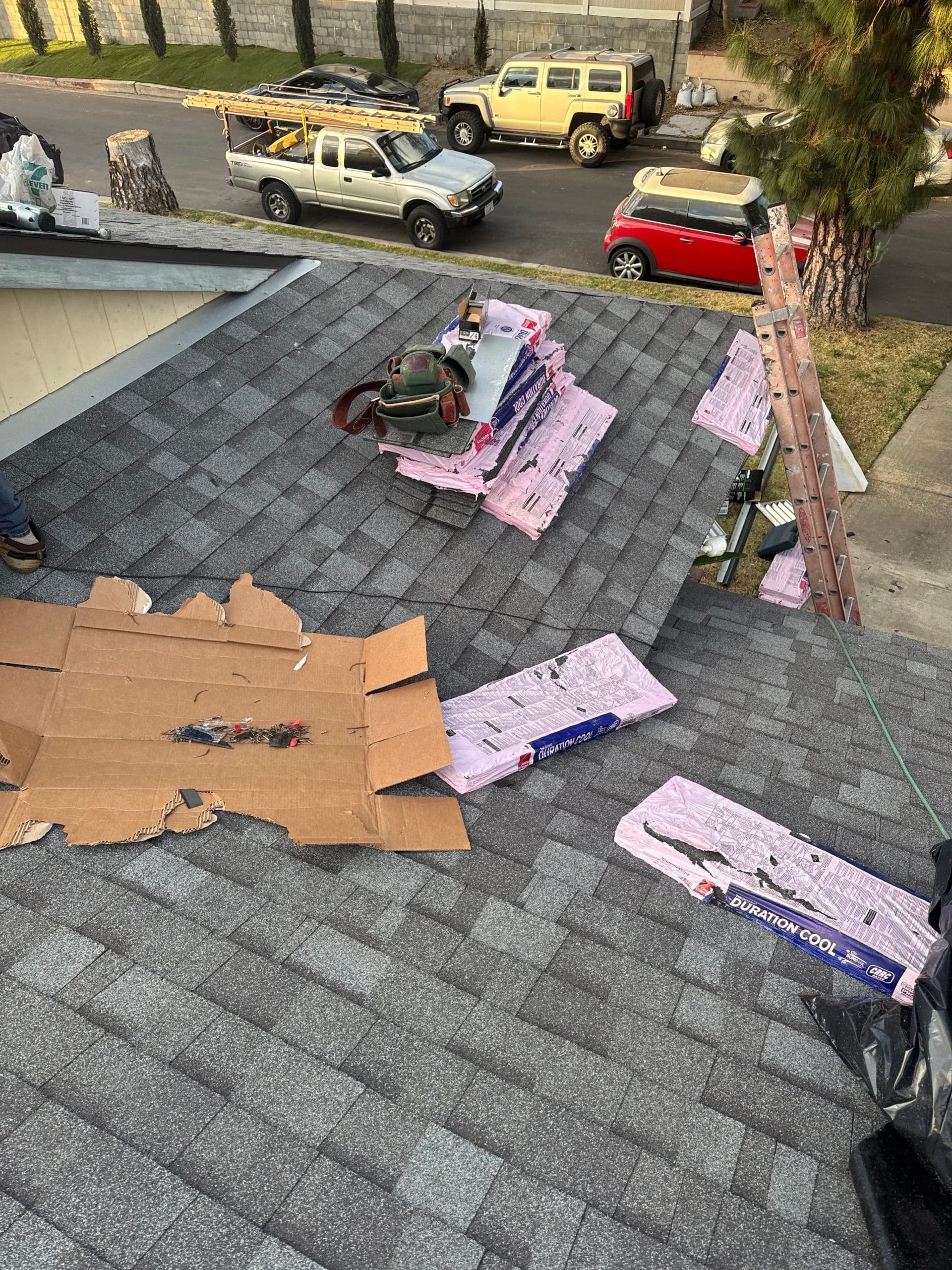 Rooftop with shingles and tools for construction work.