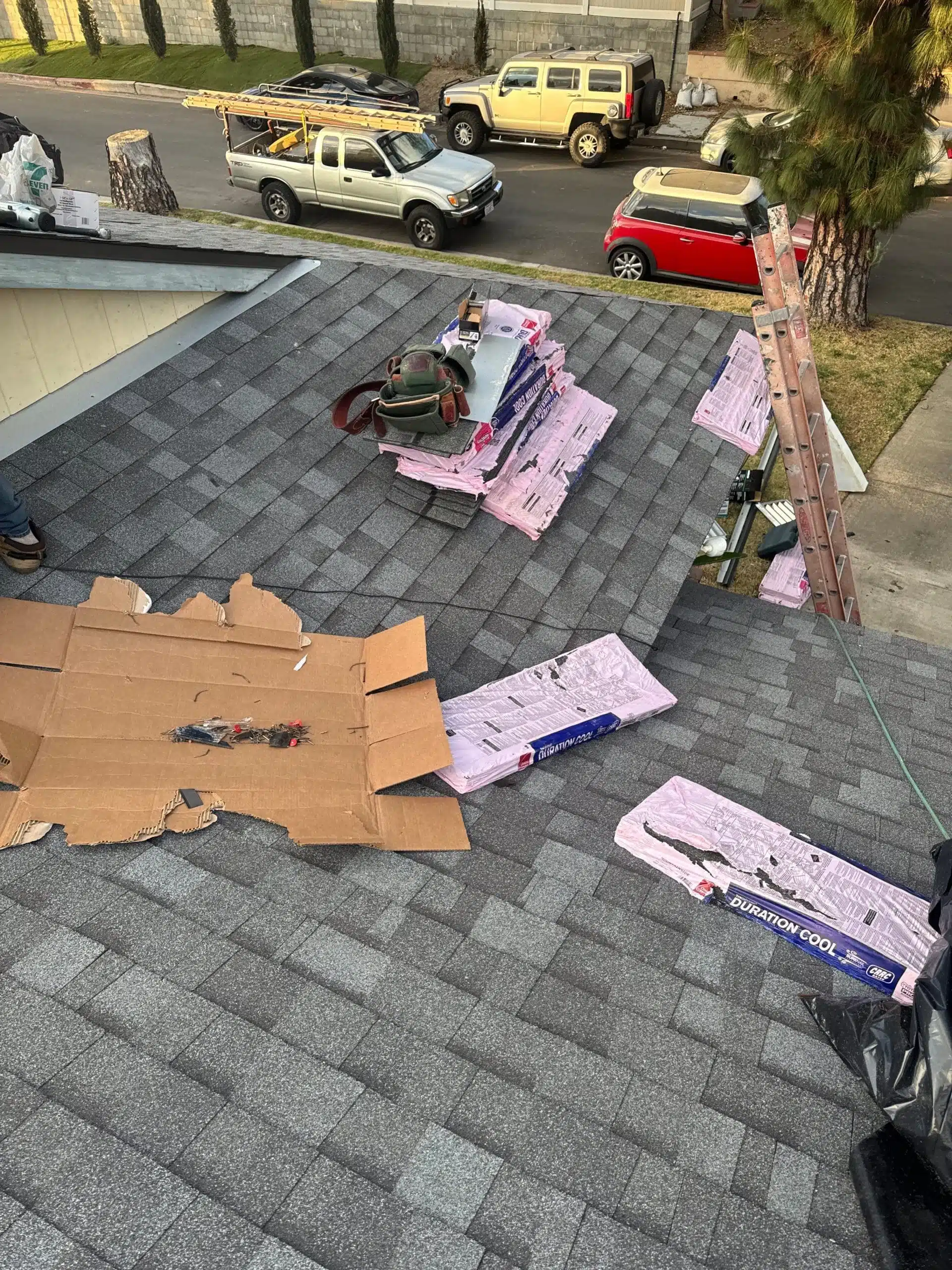 Rooftop with shingles and tools for construction work.