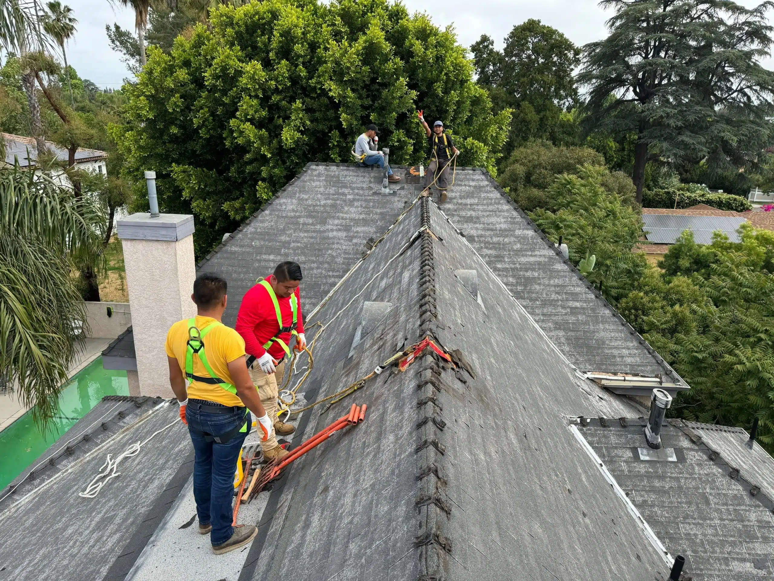 two roofers fixing a shingle roof in los angeles