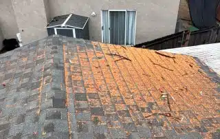 House roof with debris and visible damage.