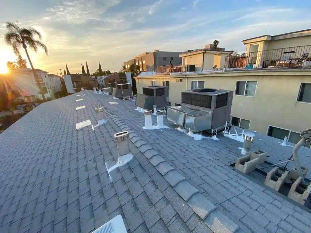 Roof Repair & Construction Inc technician sealing vent pipe flashing with tape