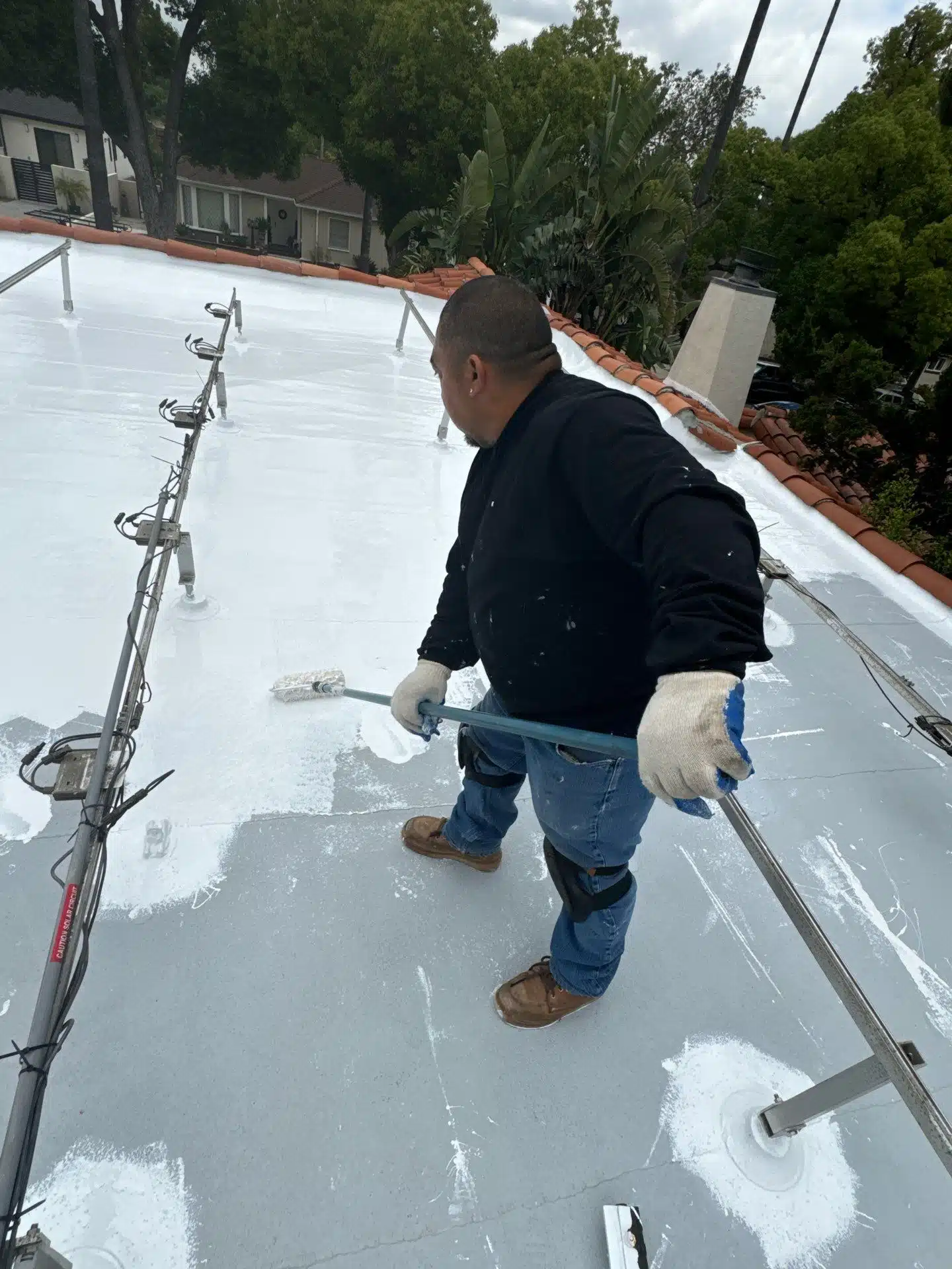 Roof Repair & Construction Inc applying sealant to flat roof