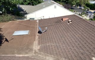 Brown shingle roof with satellite and vents.
