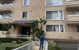 Apartment building with entrance and person walking.