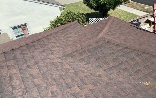 Brown shingle roof with residential background.