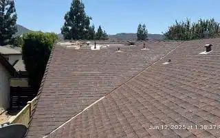 11-Jun 12 2025 01_38pm-2tB6 House roof with damaged shingles, clear sky background.