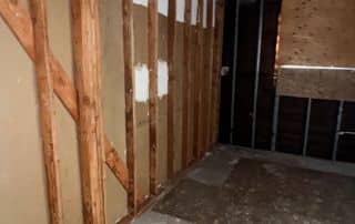 Empty unfinished room with exposed wooden walls.