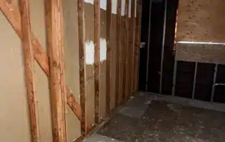 Empty unfinished room with exposed wooden walls.