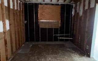 Empty unfinished room with exposed wooden frame.
