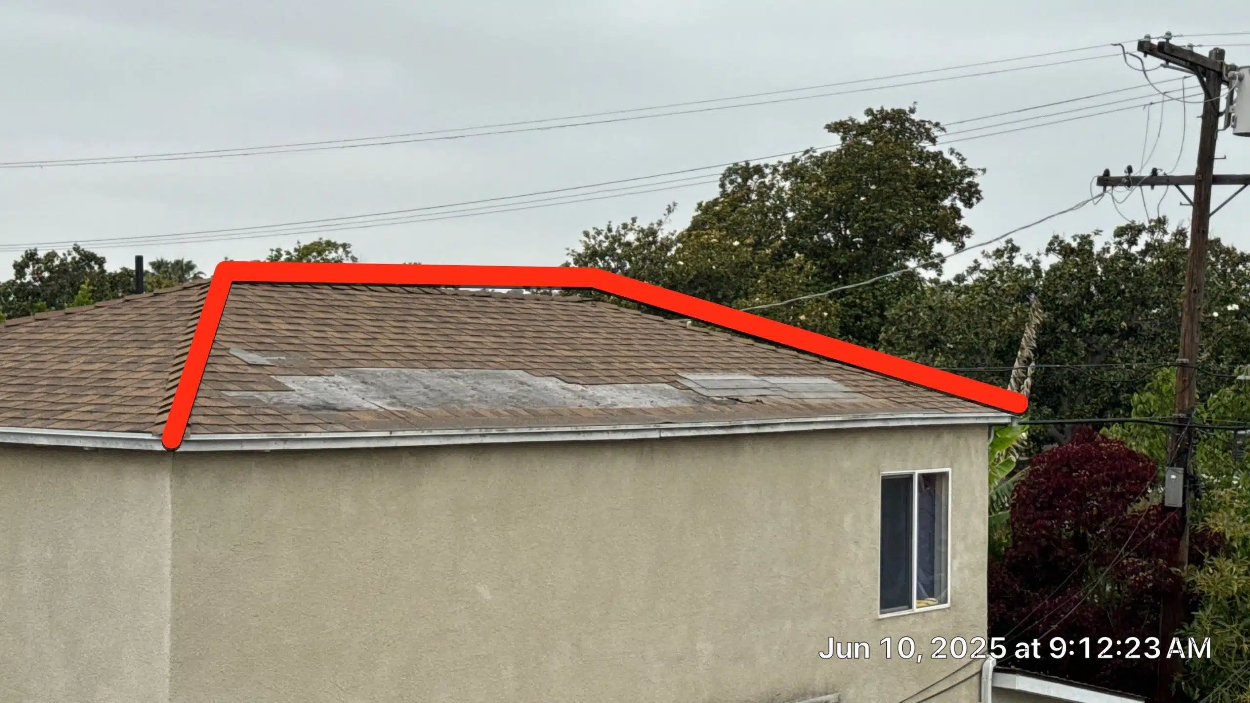 Damaged roof with missing shingles highlighted in red.
