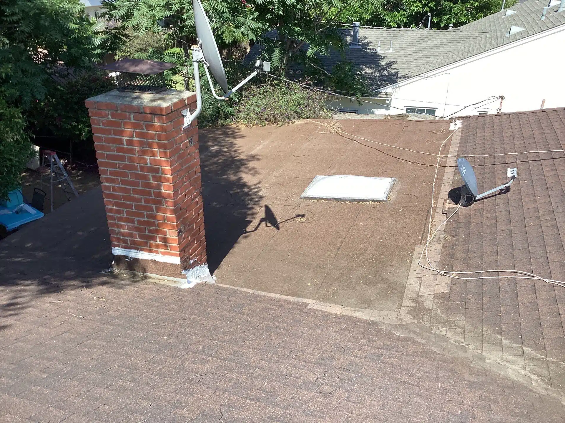 House rooftop with chimney and satellite dish.