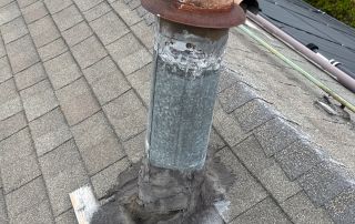 Roof vent with wood cover on shingles.