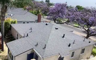 House with gray roof and purple flowering trees