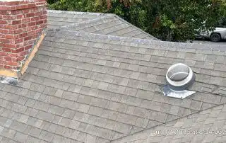 30-Jun 12 2025 08_34am-gxb7 Brick chimney and skylight on shingled roof.