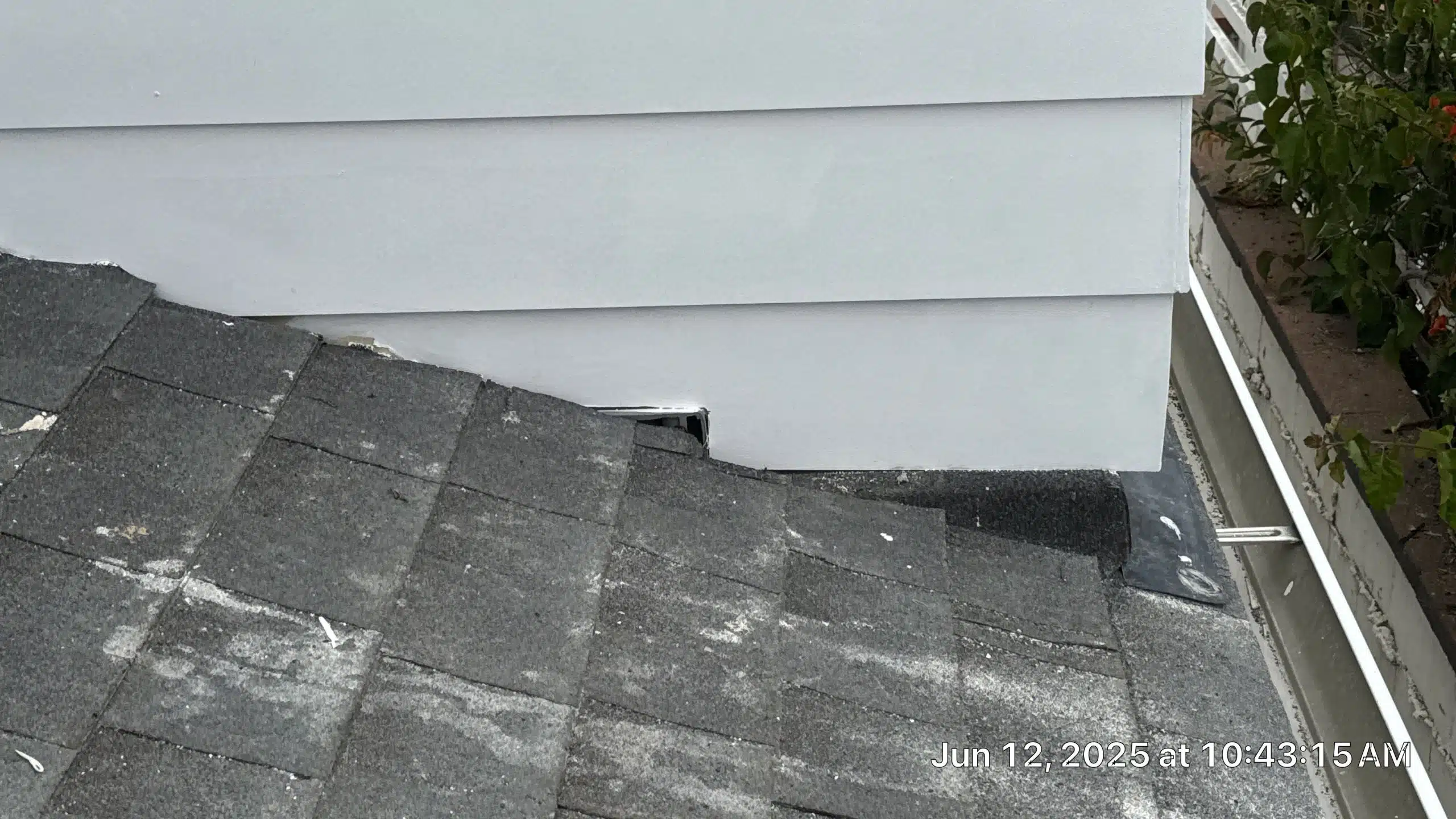 33-Jun 12 2025 10_43am-GauF Close-up of rooftop shingles meeting white siding.