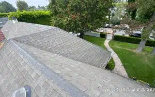 35-Jun 12 2025 08_35am-uzqE Gray shingle roof, green yard, and brick chimney view.