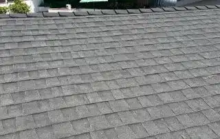 35-Jun 26 2025 10_57am-7Cqr Gray shingle roof with trees and blue sky.