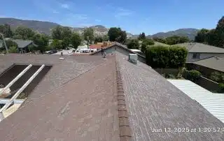36-Jun 12 2025 01_39pm-gCD3 View from rooftop, houses and mountains visible.