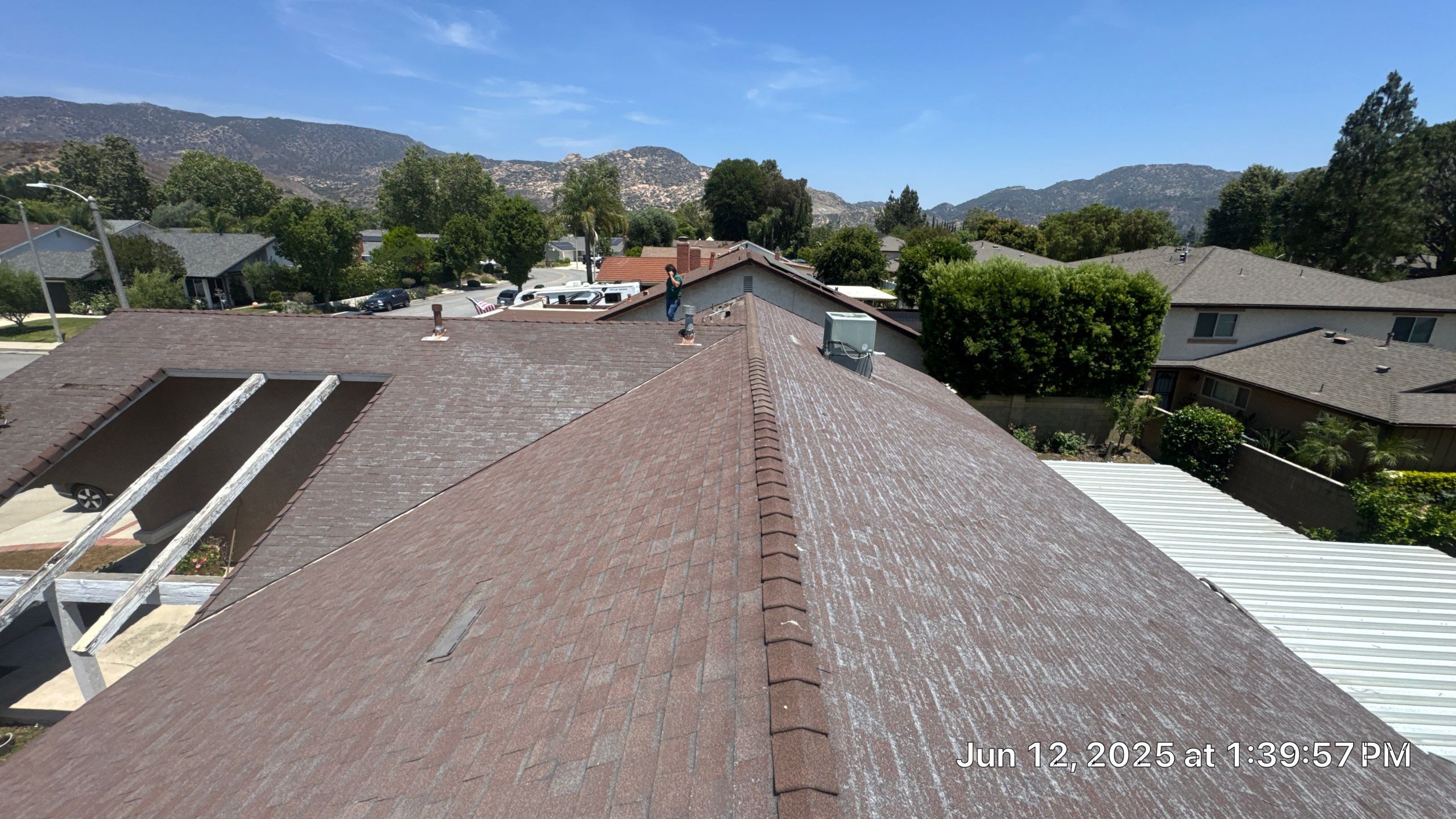 View from rooftop, houses and mountains visible.