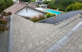 View of roof and solar panels with pool