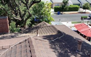 Suburban street view from rooftop with trees and houses.