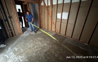 Person measuring room with tape measure during renovation