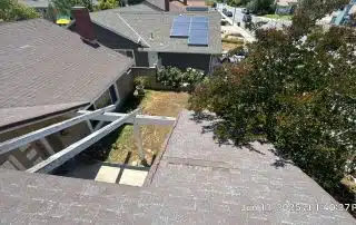 40-Jun 12 2025 01_40pm-opan Aerial view of house roofs and yard.