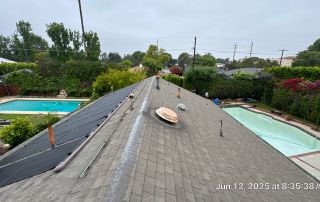 Rooftop solar panels near swimming pools, outdoor view.