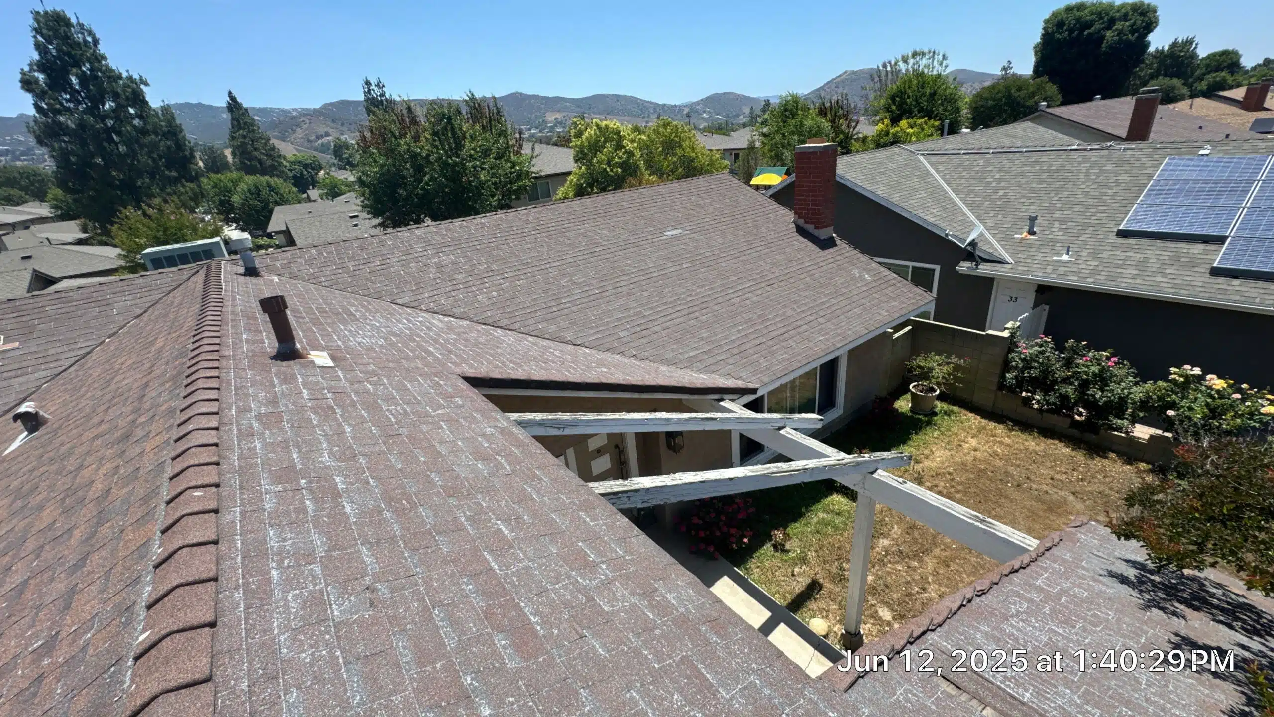 43-Jun 12 2025 01_40pm-BBso Residential rooftops with solar panels and distant mountains.
