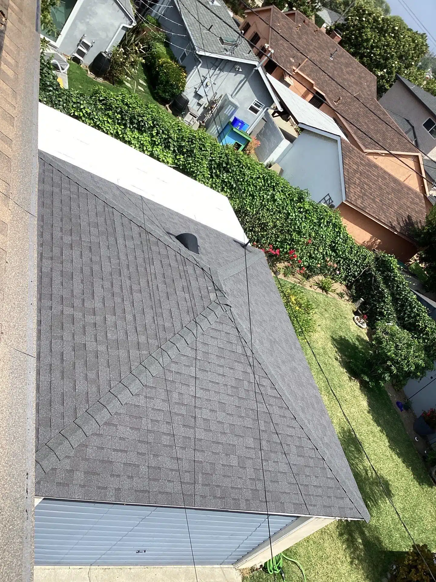 Aerial view of residential rooftops and gardens.