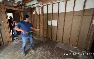 Person measuring wall in house under renovation