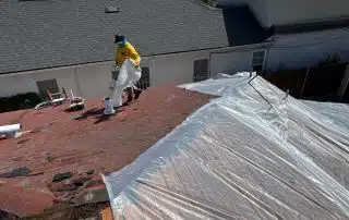 Worker repairing roof under clear sky