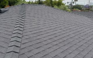 Gray shingled roof under cloudy sky.