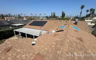 Roof with solar panels and workers on top.