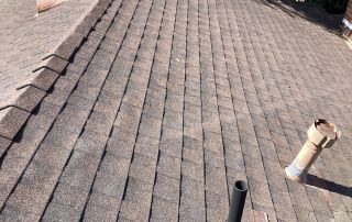 Newly installed asphalt shingle roof with chimneys
