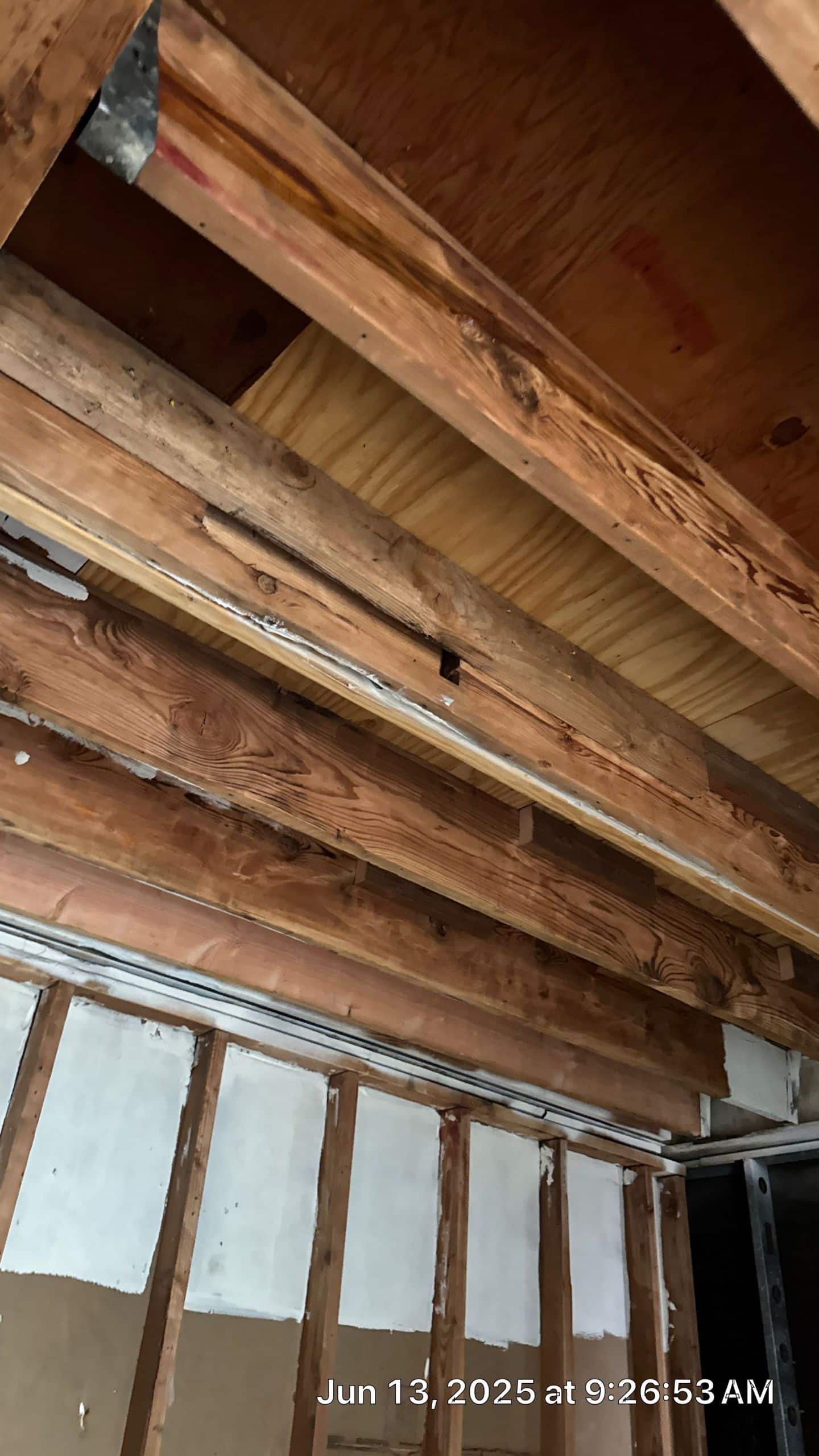 7-Jun 13 2025 09_26am-ygaM Exposed wooden ceiling beams in construction site.