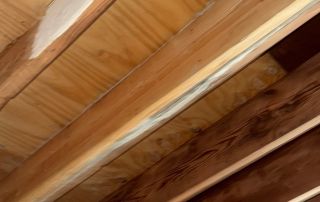 Exposed wooden ceiling beams and drywall repair.
