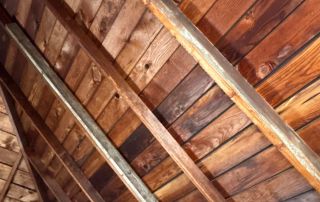Wooden garage attic ceiling with metal reinforcement beams.