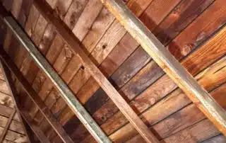 Wooden garage attic ceiling with metal reinforcement beams.