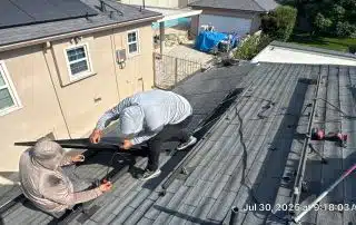 Workers installing solar panels on a roof.