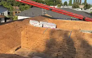 Rooftop construction with wooden planks and tools.