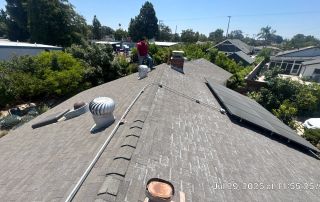 Person inspecting a roof with solar panels.