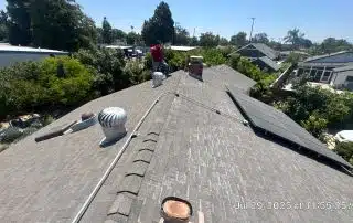 Person inspecting a roof with solar panels.