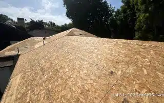 New plywood roof under construction on a sunny day.